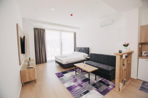 a living room with a couch and a bed at KS Apartments in Visoko