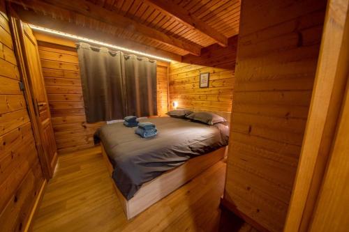 a bedroom in a log cabin with a bed in it at Pétillant Chalet aux 3 étangs avec SPA, Sauna et Véranda in Gerbépal