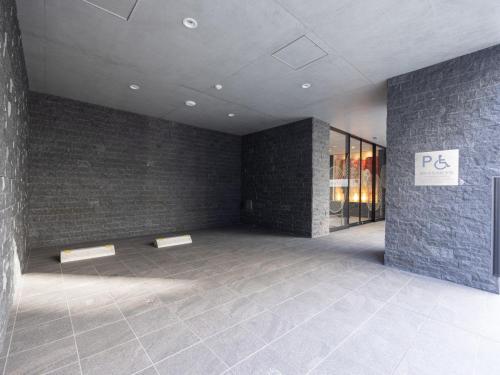 an empty room with a sign on a brick wall at La'gent Hotel Kyoto Nijo in Kyoto