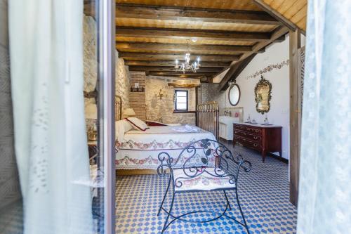 a bedroom with a bed and a bench in a room at El Rincón de Hornuez in Moral