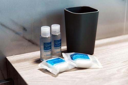 a table with toothbrushes and toothpaste and a cup at Lario Suite Apartments by Quokka 360 - With parking Next to Como City in Como