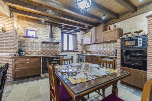 a kitchen with a table with chairs and a stove at El Rincón de Hornuez in Moral