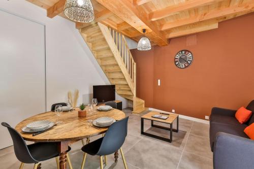 une salle à manger avec une table et des chaises en bois dans l'établissement Le Cognaçais #Clim #1 à 4 pers, à Cognac