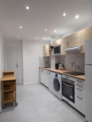 Il comprend une cuisine équipée d'une cuisinière et d'un lave-vaisselle. dans l'établissement Évasion La Défense - Balcon & Wi-Fi, à 10 min de Paris, à Courbevoie