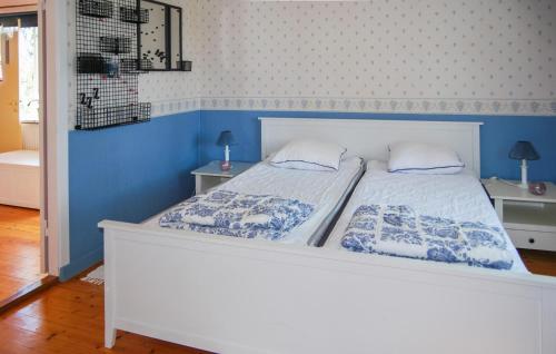 a bedroom with a white bed with blue walls at 4 Bedroom Nice Home In Mörbylånga in Mörbylånga