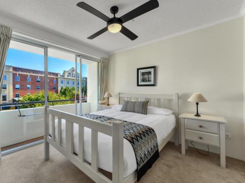a bedroom with a large bed and a large window at Goldsborough Place Apartments in Brisbane