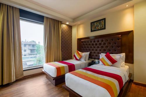 a hotel room with two beds and a window at The Grand Orion - Kailash Colony in New Delhi