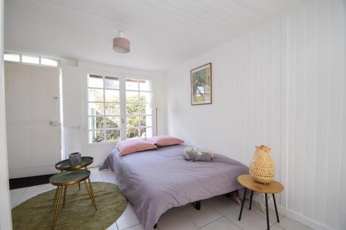 Una habitación blanca con una cama y una ventana en Le Chalet Ma Neizh - 4 pers avec jardin, en La Richardais