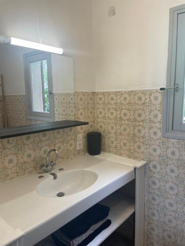 une salle de bain avec un lavabo et un miroir dans l'établissement Villa Ondella vue mer et piscine privée, à Grosseto-Prugna