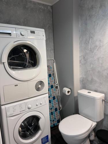 a bathroom with a washing machine and a toilet at Downtown Apartments in Plzeň