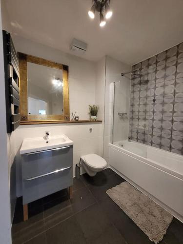 a bathroom with a sink and a toilet and a tub at Spacious Leicester Apt with Free Parking, Sleeps 6 in Leicester