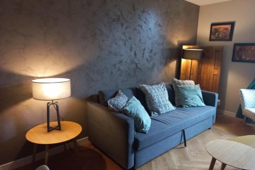 un salon avec un canapé bleu avec des oreillers dans l'établissement Charmant T2 refait à neuf Annecy centre et lac, à Annecy