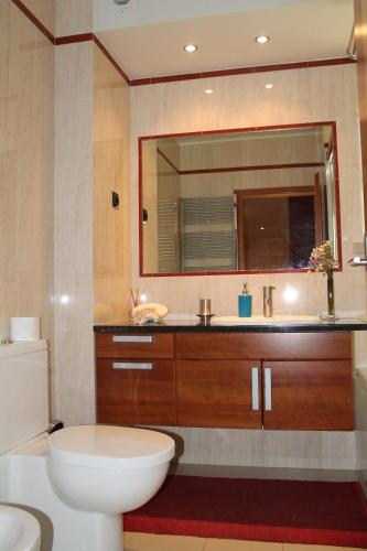 a bathroom with a toilet and a sink and a mirror at Top Quality Apartment in Lagos