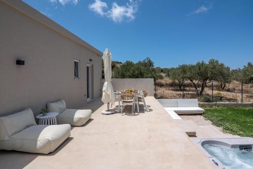 a patio with a table and chairs and an umbrella at Christini Secrets in Plátanos