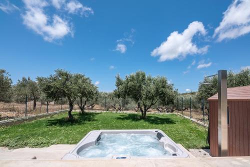 a hot tub in the middle of a field with trees at Christini Secrets in Plátanos