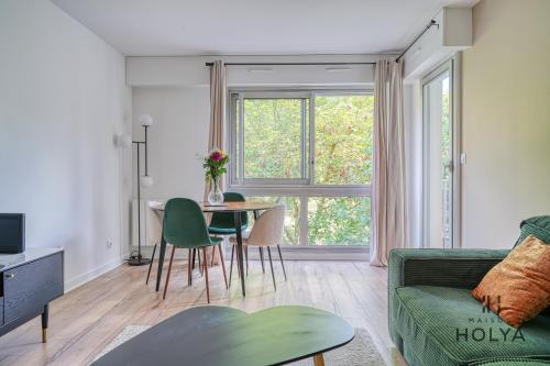 un salon avec un canapé vert et une table dans l'établissement Le Bora - Proche de Paris - 339B, à Nogent-sur-Marne