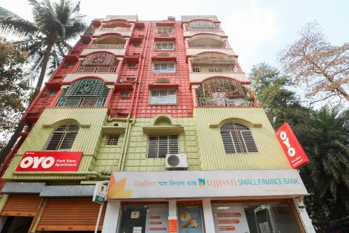 a tall yellow and red building with a store at Super Hotel O Adri Hotels in Kolkata