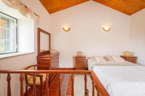 a bedroom with a bed and a mirror and a window at Cosy apartment at Portuguese Quinta in Casal Diz