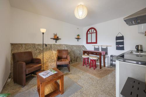 a living room with a table and chairs and a kitchen at Cosy apartment at Portuguese Quinta in Casal Diz