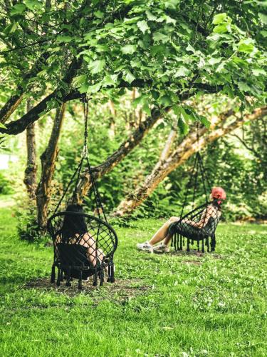 two people sitting on swings in a park at Nasze Calle in Węgorzewo