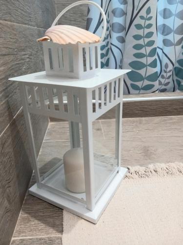 a white toy bird house with a basket on it at TOLUAMMARE Sicily in Santa Maria Del Focallo