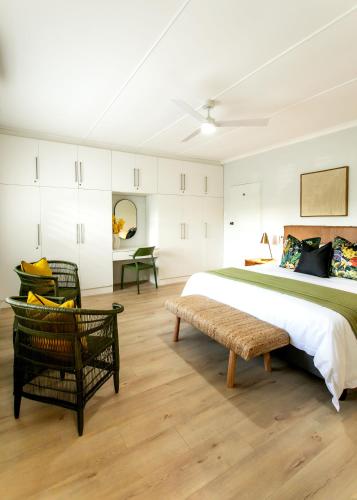 a bedroom with a large bed and a chair at Happy Hideaway in Hermanus