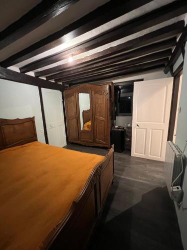 a bedroom with a large bed with a wooden frame at Venez respirer l'air de la Campagne a 70 km de de l'Océan, Villers sur Mers , Deauville ..... Maison de 100 m² ,sur une parcelle de 2000 m² 3 chambres toutes refaites , 2 salles d'eau , 2 toilettes , cuisine équipées . tous refait a neuf in Monnai