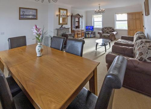 a living room with a wooden table and a couch at Matthews Cottage Doonbeg sleeps 6 by Trident Holiday Homes in Doonbeg