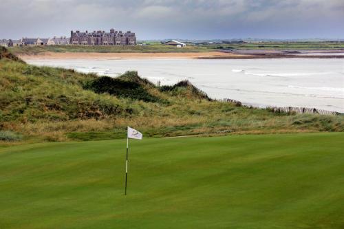 a view of a golf course with a flag at Matthews Cottage Doonbeg sleeps 6 by Trident Holiday Homes in Doonbeg