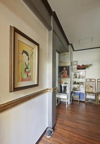 a living room with a painting on the wall at Jiwoljang Guesthouse in Seoul