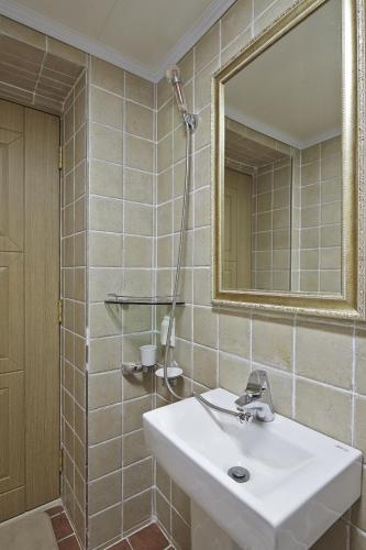 a bathroom with a white sink and a mirror at Jiwoljang Guesthouse in Seoul