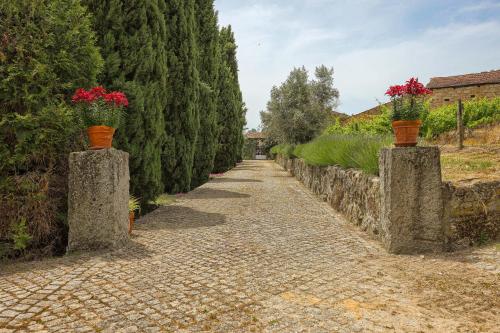 a stone path with two vases with flowers on them at Cosy apartment at Portuguese Quinta in Casal Diz