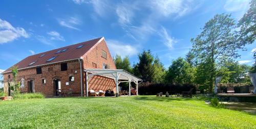an old brick barn with a tent in a yard at INGLOTÓWKA in Wołów