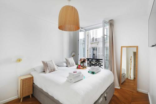 un grand lit blanc dans une chambre avec une fenêtre dans l'établissement Trendy apartment - 2BR-4P - Saintonge-Le Marais, à Paris
