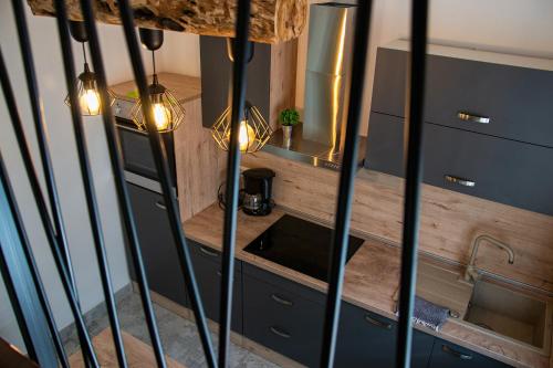 a kitchen with a counter with a sink and lights at Charming house Maša in Rakovica