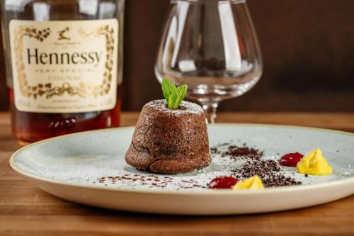 a dessert on a plate with a bottle of wine at GLUTEN FREE Bed & Breakfast Dežela Okusov in Ljubljana