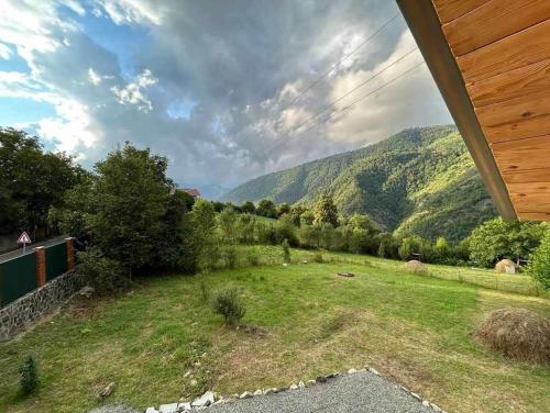une vue d'un champ avec des montagnes en arrière-plan dans l'établissement Forest Cottage, à Sadgeri