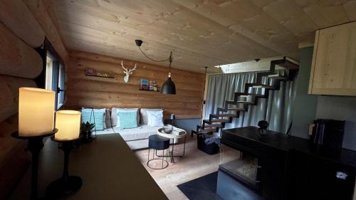 a living room with a spiral staircase in a house at Maiensäss, Berghütte Chlara - autark, voll ausgestattet, Ressourcen begrenzt in Untervaz