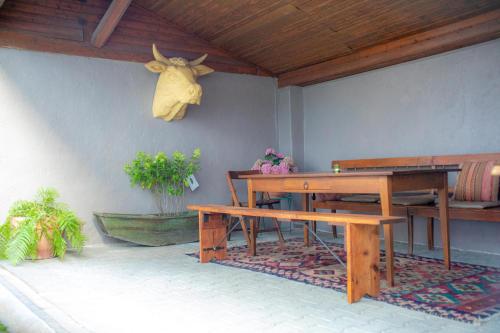 a table and bench on a patio with a skull on the wall at Landhof PAU in Mappershain