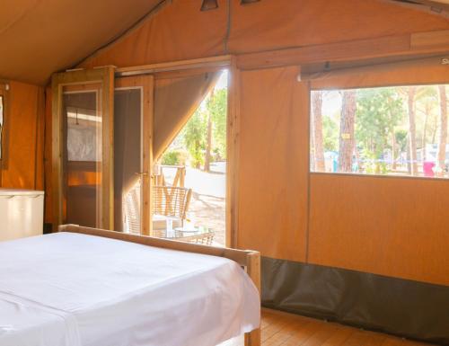 a bedroom with a bed and a sliding glass door at Gitavillage Talamone in Talamone