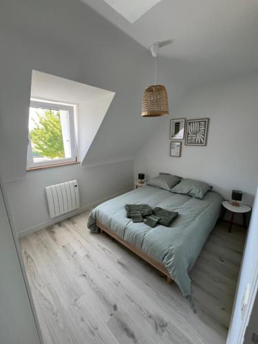 a bedroom with a large bed and a window at Jolie maison bord de mer in Dinard
