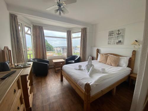 a bedroom with a bed and a desk and a window at The Grand Hotel in Skegness
