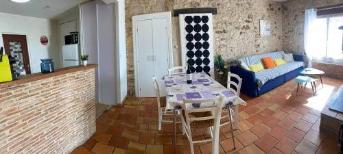 un salon avec une table et un canapé bleu dans l'établissement Maison de campagne en pierres 4 personnes, à Gardonne
