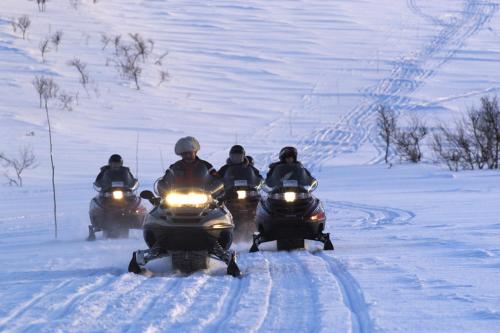 a group of people riding motorcycles through the snow at Lakselv Hotel in Lakselv