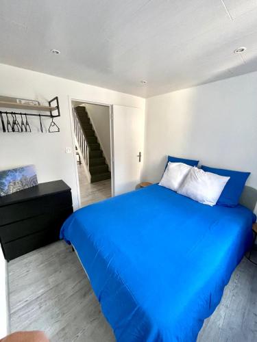 - une chambre avec un lit bleu et un escalier dans l'établissement Appartement T3 type Duplex, à Marseille