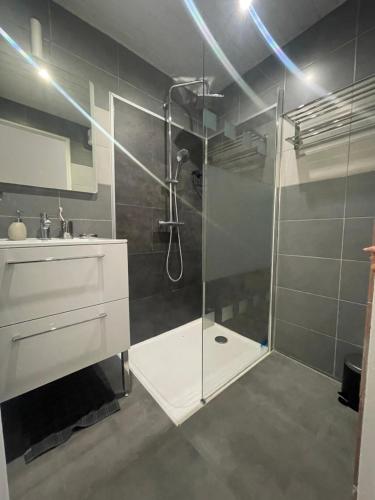 La salle de bains est pourvue d'une douche, d'un lavabo et d'une cabine de douche en verre. dans l'établissement Appartement T3 type Duplex, à Marseille