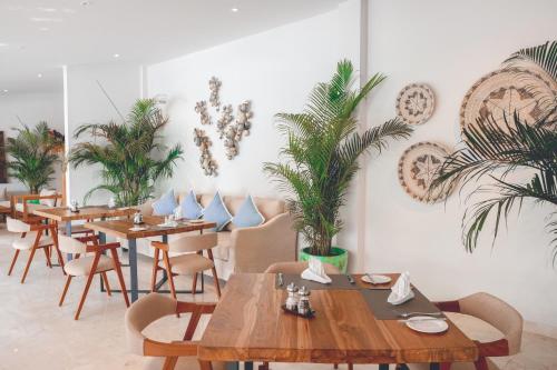 a restaurant with tables and chairs and palm trees at Impiana Private Villas Seminyak in Seminyak
