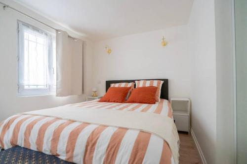 - une chambre blanche avec un grand lit et des oreillers orange dans l'établissement Central Apartment Paris Opera Garnier, à Paris