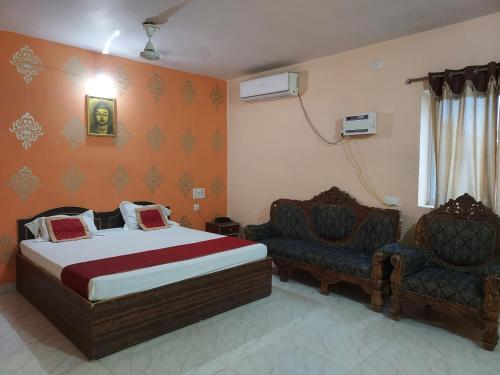 a bedroom with a bed and two chairs at Hotel Maurya Vihar Bodhgaya in Bodh Gaya