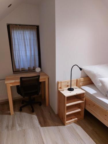 a bedroom with a desk and a bed and a chair at Ferienwohnung Bohinj in Bohinjska Bistrica